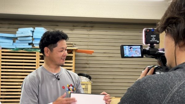 漆喰サンプルを手に左官の説明をする横山さん