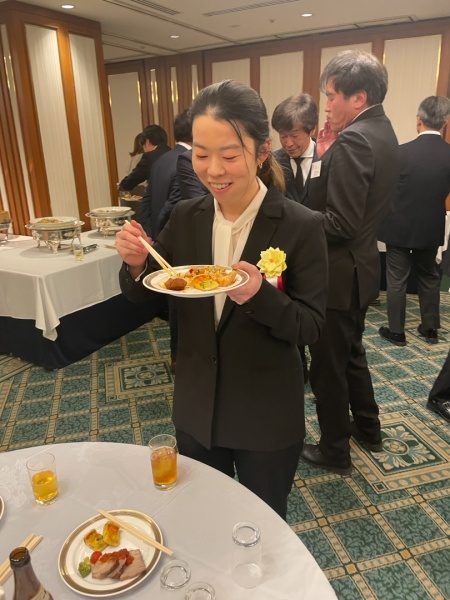 賀詞交歓会にて笑顔で食事中の原田左官タイル工見習いの下村さん